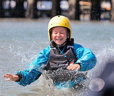 Person wearing a yellow helmet and blue jacket in water